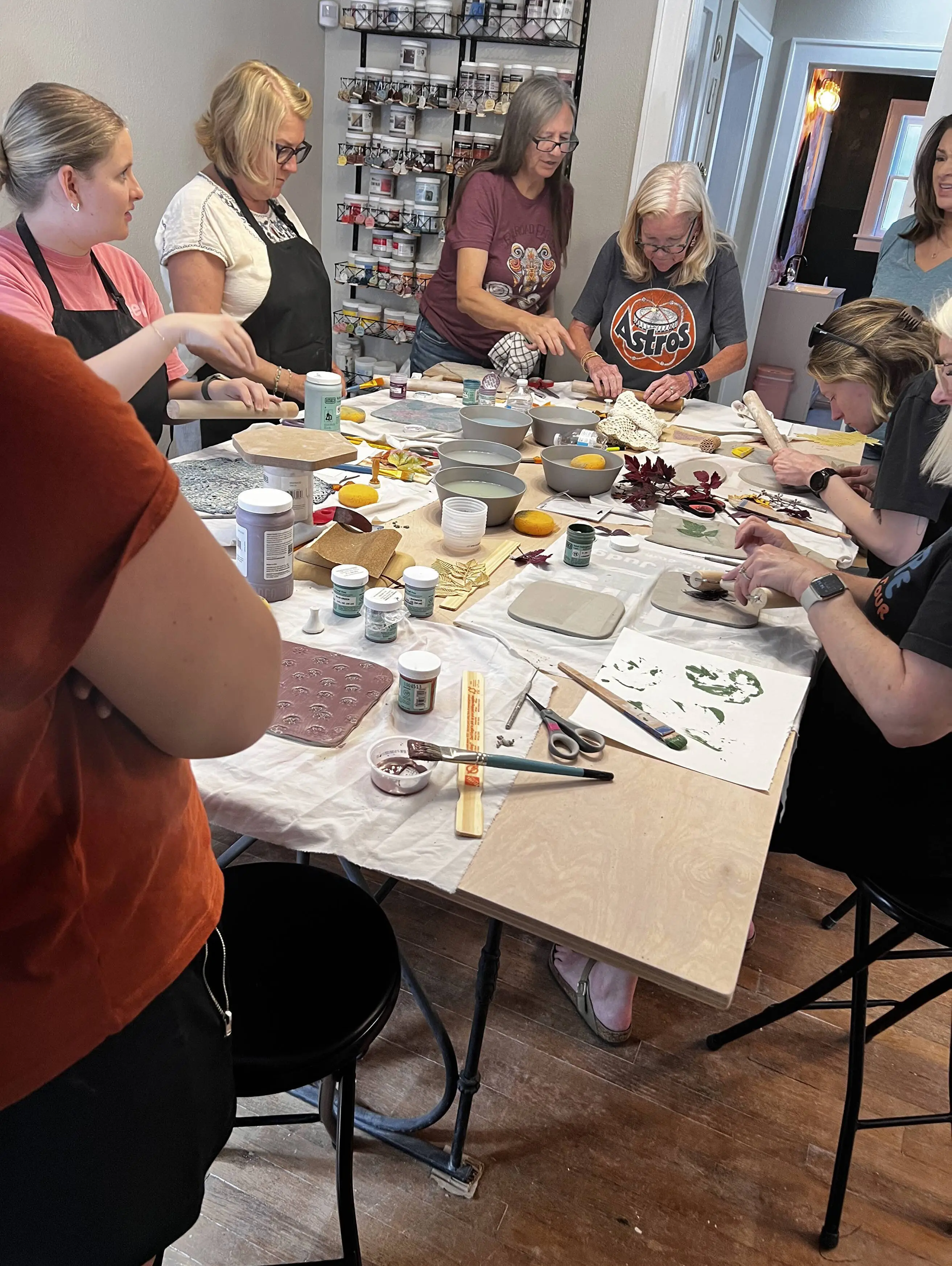 Friends around a worktable at a private pottery party